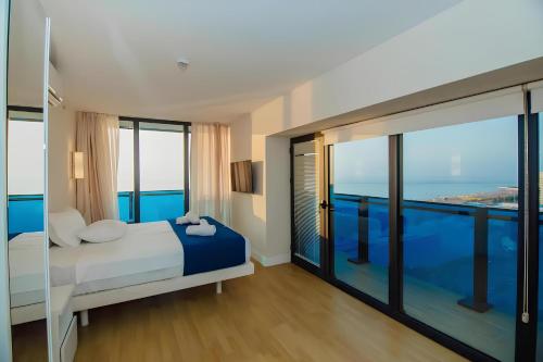 a bedroom with a bed with a view of the ocean at Panorama Luxury SeaView in Batumi