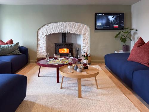 - un salon avec un canapé et une cheminée dans l'établissement Luxury 4-Bed Farmhouse Retreat in Yorkshire Dales, à Gaisgill