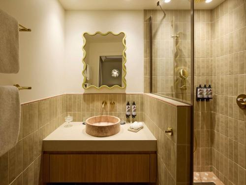 a bathroom with a sink and a shower at Grand Hôtel Roi René Aix - MGallery Collection in Aix-en-Provence
