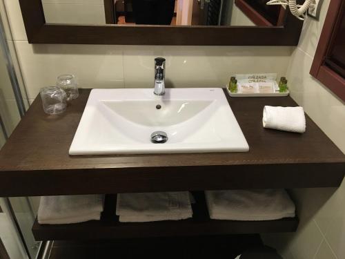 a bathroom counter with a sink and a mirror at Hotel Calzada in Arcos