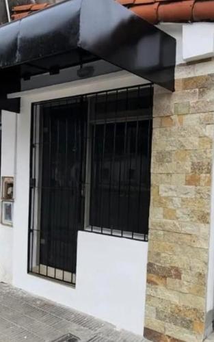 a window with black bars on the side of a building at LU DORMIS 2 - Artigas - Alquiler Temporario in Corrientes