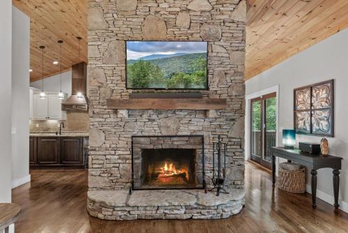 a stone fireplace in a living room with a window at Starlight Ridge in Seven Devils
