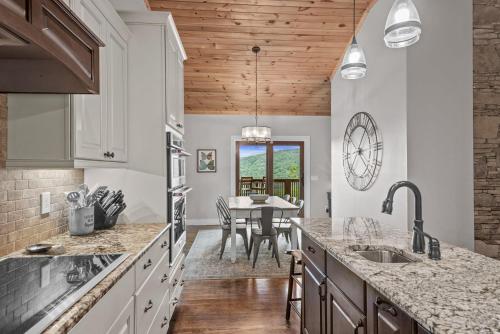 a kitchen with white cabinets and a dining room with a table at Starlight Ridge in Seven Devils
