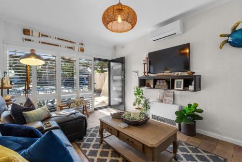 a living room with a couch and a table at Peaceful Retreat Steps from Semaphore Beach in Semaphore
