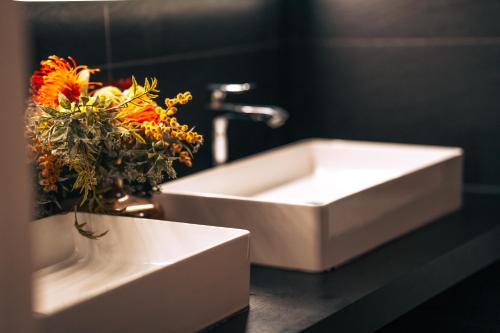 a white sink and a vase of flowers in a bathroom at ZevenVrijeDagen in Ghent