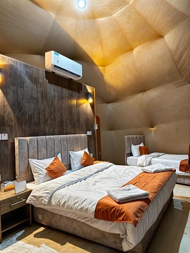DisahにあるRUM STAR LOTE LUXURY CAMp & BUBBLES ROOMの天井の客室のベッド2台