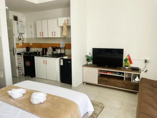 ein Wohnzimmer mit einem TV und einer Küche in der Unterkunft Confort & Céntrico Full Equipado Turístico in Santa Cruz de la Sierra