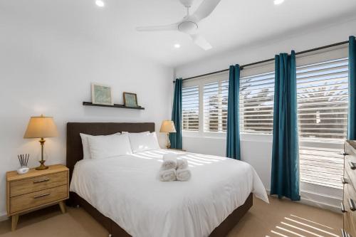 a bedroom with a large bed with blue curtains at Peaceful Retreat Steps from Semaphore Beach in Semaphore