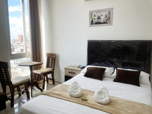 ein Schlafzimmer mit einem großen weißen Bett mit einem großen Fenster in der Unterkunft Confort & Céntrico Full Equipado Turístico in Santa Cruz de la Sierra