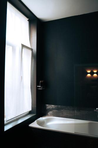 a black bathroom with a tub and a window at ZevenVrijeDagen in Ghent