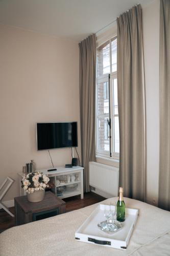 a room with a bed and a window with a bottle of wine at ZevenVrijeDagen in Ghent