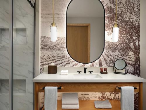 a bathroom with a sink and a mirror at The Ava Hotel Paso Robles, Curio Collection By Hilton in Paso Robles