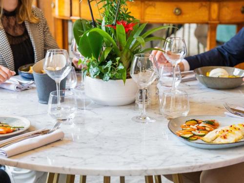 a table with plates of food and glasses of wine at Mercure Lyon Centre Château Perrache in Lyon