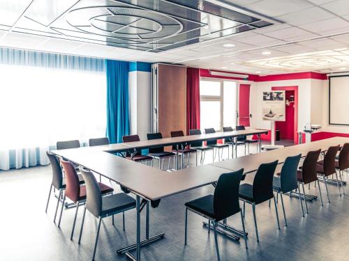 a conference room with a long table and chairs at Mercure Lyon Centre Château Perrache in Lyon