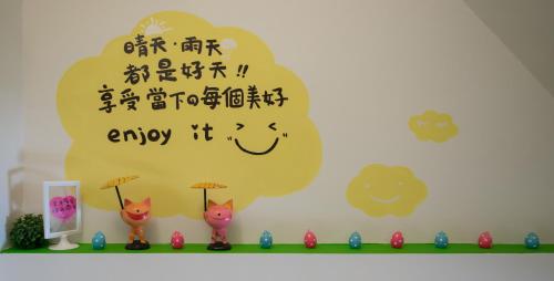 a wall with hello kitty figurines in front of a shelf with a sign at Have FUN villa in Hengchun