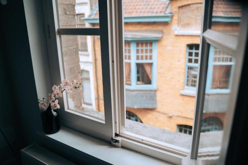 a window with a vase of flowers on a window sill at ZevenVrijeDagen in Ghent
