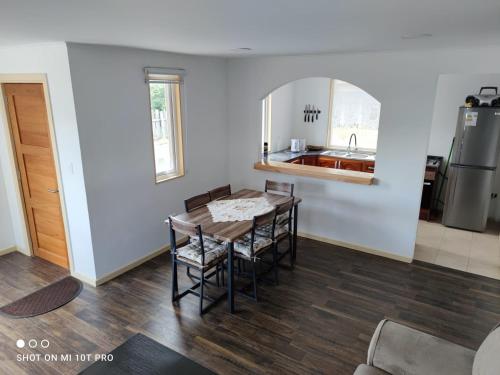 a kitchen with a table and chairs and a sink at Cabañas 1 Olimai in Puerto Natales