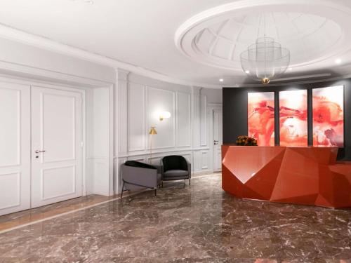 a lobby with a table and a painting on the wall at Sofitel Roma Villa Borghese in Rome