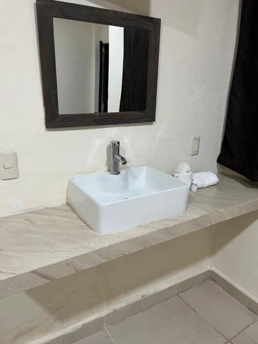 a white sink in a bathroom with a mirror at Hotel Rio Maya in Palenque