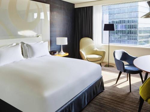 a hotel room with a bed and a table and chairs at Sofitel Luxembourg Europe in Luxembourg