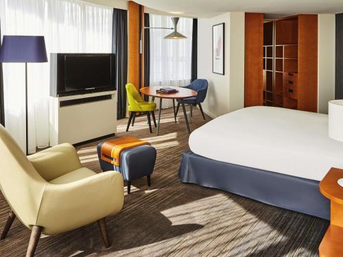 a hotel room with a bed and a table and chairs at Sofitel Luxembourg Europe in Luxembourg