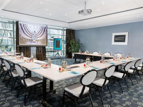 a conference room with tables and chairs and a stage at Sofitel Luxembourg Europe in Luxembourg