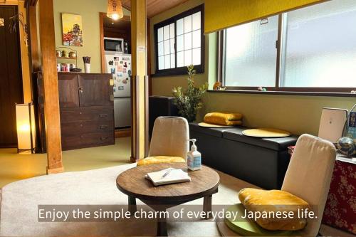 a living room with a table and two chairs and a table and a table at Kanazawa Guesthouse Pongyi in Kanazawa
