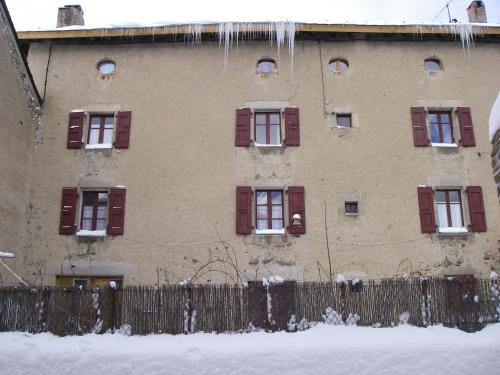 un bâtiment avec des fenêtres rouges à volets et une clôture dans l'établissement La Maison Bleue, à La Cabanasse