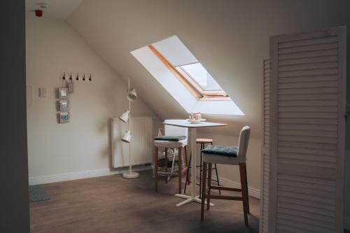 a attic room with a table and a skylight at ZevenVrijeDagen in Ghent