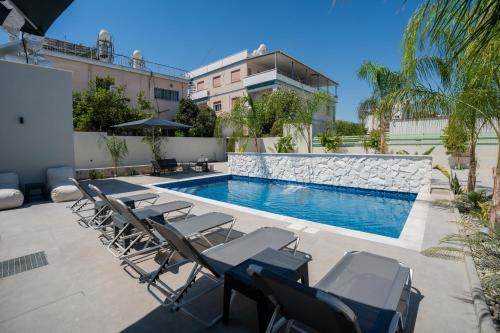 a group of chairs sitting next to a swimming pool at Raise Cityscape Limassol Suites in Limassol