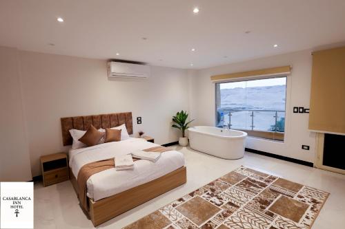 a bedroom with a large bed and a bath tub at Casablanca pyramids inn in Cairo