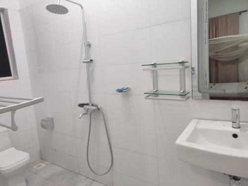a white bathroom with a shower and a sink at Nils Home in Nungwi