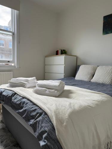 Un dormitorio con una cama con toallas. en London Luxe Escape, en Londres