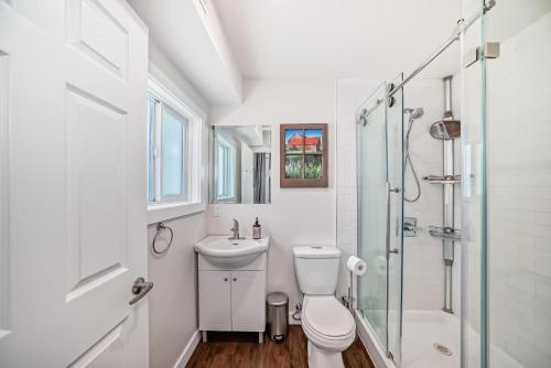 a bathroom with a shower toilet and a sink at Laneway Carriage House in Calgary