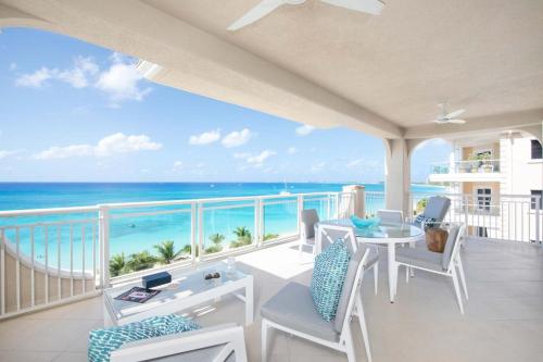 a balcony with a table and chairs and the ocean at Beachcomber 35 in George Town