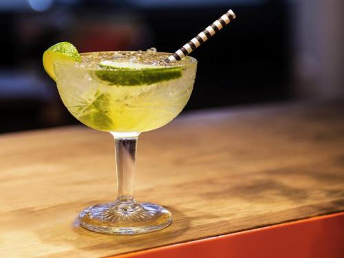 a martini glass with a lime and a straw at ibis Amsterdam Centre in Amsterdam