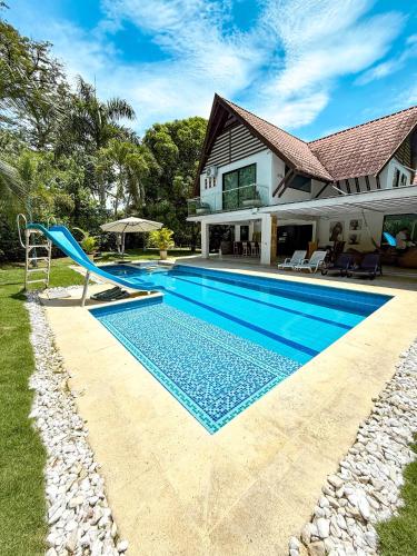 a swimming pool with a slide in front of a house at Cabaña en santafe de Antioquia in Santa Fe de Antioquia