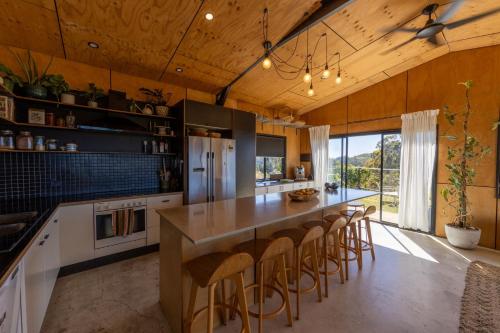 Eine Küche mit einer großen Kochinsel und Barhockern in der Unterkunft Ocean View Escape in Sandy Beach