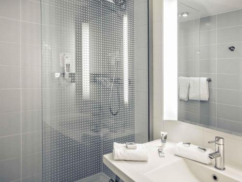 a bathroom with a glass shower and a sink at Hotel Mercure Toulouse Centre Compans in Toulouse