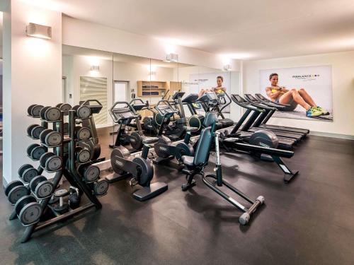 a gym with a bunch of exercise equipment in it at Novotel Melbourne On Collins in Melbourne