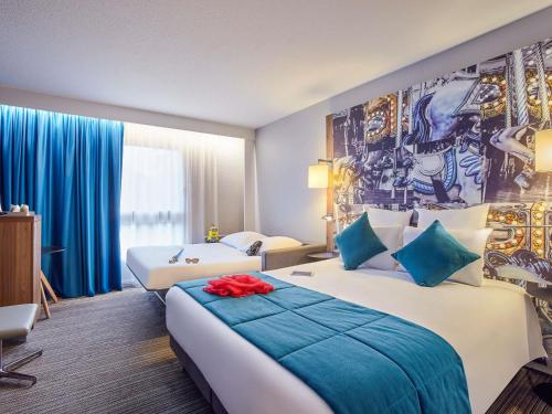 a hotel room with two beds and a mural on the wall at Hotel Mercure Château de Fontainebleau in Fontainebleau