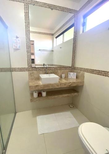 a bathroom with a sink and a mirror at Pousada Chantilly in São Miguel do Gostoso
