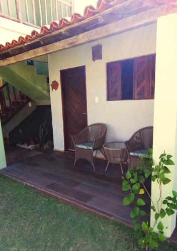 a house with a patio with chairs and a staircase at Pousada Chantilly in São Miguel do Gostoso