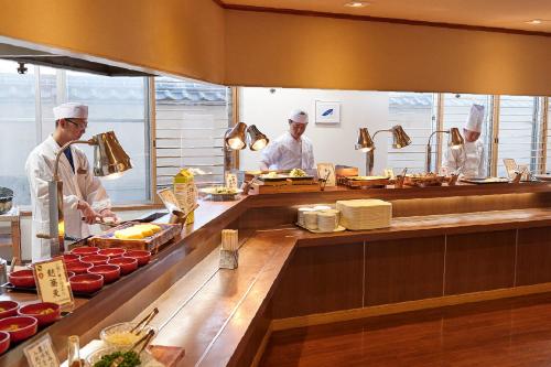 a group of chefs preparing food in a kitchen at Takinoyu Hotel in Tendo