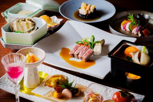 a table with several plates of food and a drink at Takinoyu Hotel in Tendo