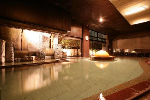 a lobby with a large pool in a building at Takinoyu Hotel in Tendo