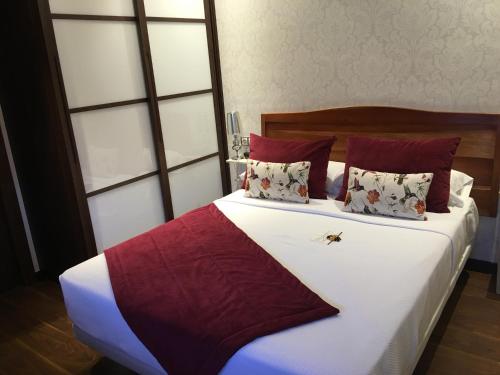 a bed with red and white sheets and pillows at Hotel Calzada in Arcos