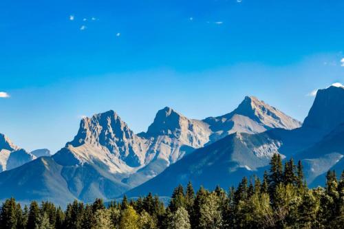 a mountain range with trees in the foreground at Gateway Suites Cozy stay to explore Banff and Canmore in Canmore