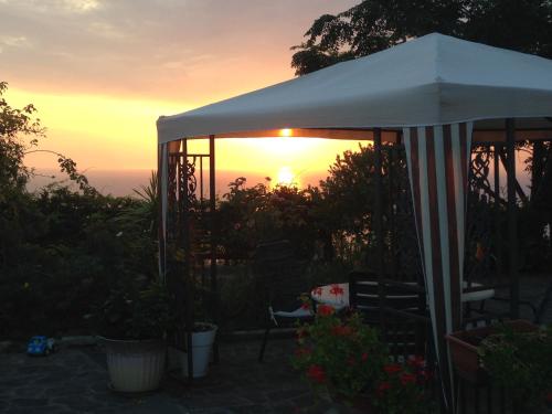 an umbrella with the sunset in the background at Villa Malandrino Guest House in Agropoli