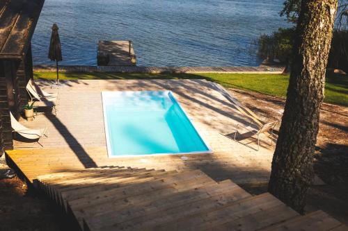 a blue swimming pool sitting next to a tree at Stay North - Adevilla in Mussalo
